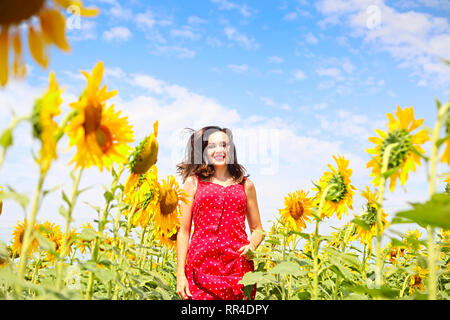 Pretty brunette womanrunning in sunflower field Stock Photo