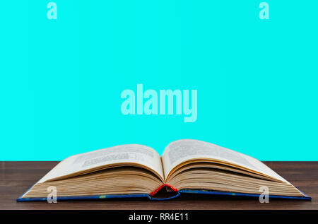 open book on a wooden surface on a blue background Stock Photo