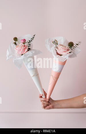 Womans hand holding   paper cones with  flowers Stock Photo