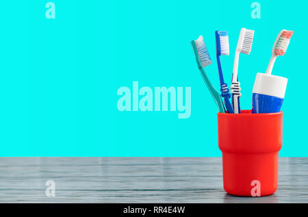 toothbrushes and toothpaste on a wooden surface on a blue background Stock Photo