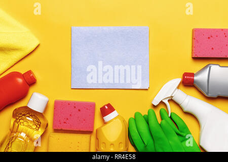 Set for cleaning various surfaces in the kitchen, bathroom and other areas. Empty place for text on yellow background. Cleaning concept. Top view Stock Photo