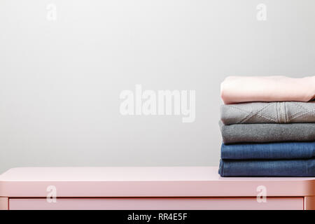 Cotton stack of colorful folded clothes on white table indoors empty space background.Household concept.Clean laundry pile. Stock Photo
