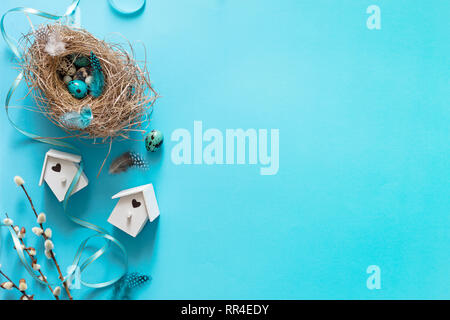 Easter quail eggs in bird nest on blue background, flat lay, copyspace. Easter holiday decorations , Easter concept background - Image Stock Photo