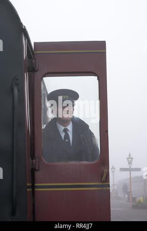 Kidderminster, UK. 24th February, 2019. UK weather: despite the thick morning fog across Worcestershire, nothing dampens the spirit of the dedicated volunteers at Severn Valley Railway.Workers on this heritage steam railway are on the platform by a vintage railway carriage definitely having fun at work! Credit: Lee Hudson/Alamy Live News Stock Photo