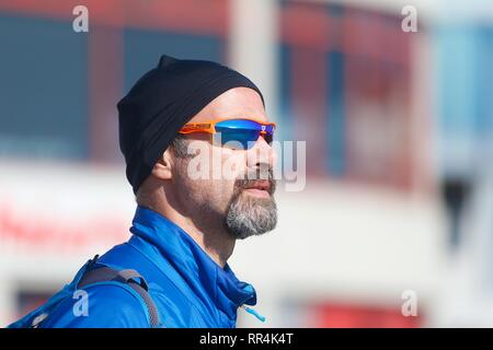 Hastings, East Sussex, UK. 24th Feb, 2019. UK Weather: Sunny but chilly wind in the seaside town of Hastings as lots of families on half term take advantage of the lovely sunny weather along the seafront promenade. Man wearing a black beany hat and sunglasses with reflection of the sun. Credit: Paul Lawrenson 2019, Photo Credit: Paul Lawrenson/Alamy Live News Stock Photo