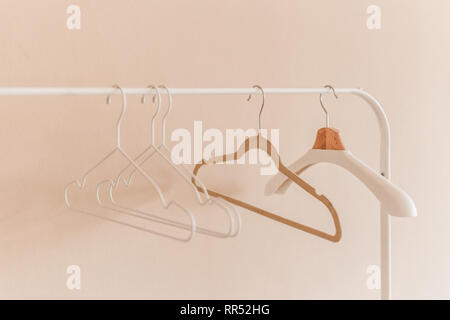 wooden coat hangers on clothes rail. Stock Photo