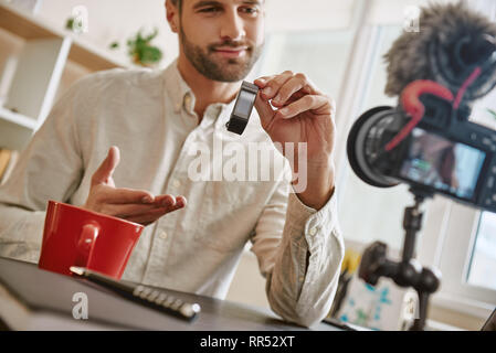 Latest model. Technology blogger reviewing about new smart watch while recording video for his Youtube channel. Technology blog. Digital. Video review Stock Photo