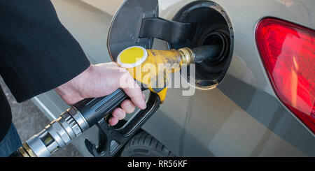 Pumping gas. Close up of man pumping fuel in car at gas station. Stock Photo