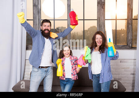 Spring cleaning. Your one stop for home cleaning needs. Happy family hold cleaning products. Mother, father and daughter clean house in spring. Ready for spring. Cleaning home before spting. Stock Photo