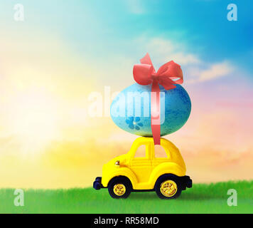 Retro toy car with Easter egg on the roof. on spring background Easter concept. Happy Easter. Stock Photo