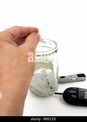 Safe disposal of Type 2 diabetics blood glucose testing lancet in sharps container Stock Photo