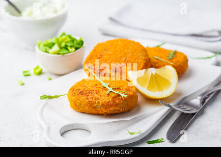 Cooked salmon fish cutlets on a white board. Stock Photo