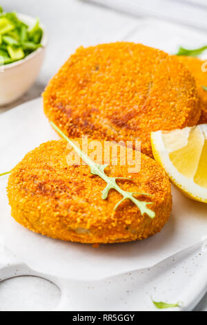 Cooked salmon fish cutlets on a white board. Stock Photo