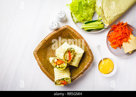 Vegan tofu wraps with cashew cheese sauce and vegetables, white background. Stock Photo