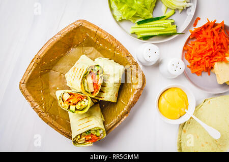 Vegan tofu wraps with cashew cheese sauce and vegetables, white background. Stock Photo