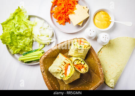 Vegan tofu wraps with cashew cheese sauce and vegetables, white background. Stock Photo