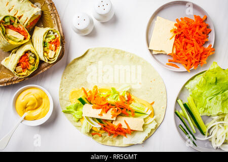 Vegan tofu wraps with cashew cheese sauce and vegetables, white background. Stock Photo