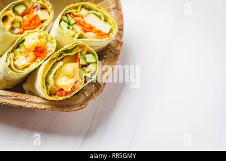 Vegan tofu wraps with cashew cheese sauce and vegetables, white background, copy space. Stock Photo