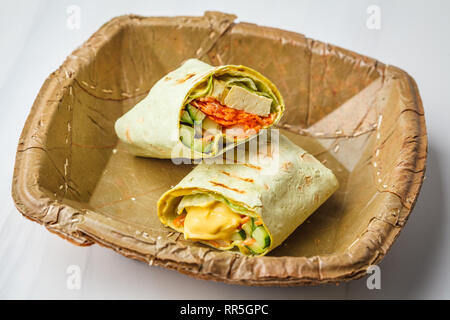 Vegan tofu wraps with cashew cheese sauce and vegetables, white background. Stock Photo