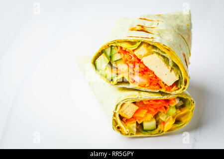 Vegan tofu wraps with cashew cheese sauce and vegetables, white background. Plant based food concept. Stock Photo