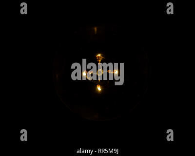 lightbulb on dark background with bright yellow shining wire Stock Photo