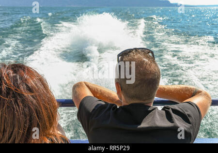 LAKE GARDA, ITALY - SEPTEMBER 2018: Two people sitting on the back of a fast ferry on Lake Garda. Stock Photo