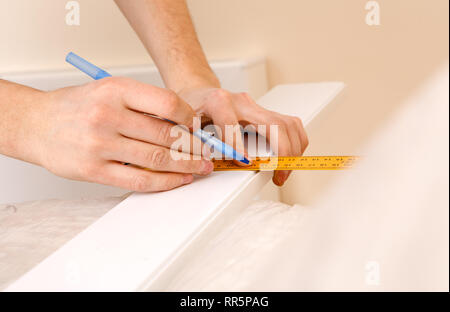 Close up view of hardworking holding ruler and pencil while making marks on the wood at table Stock Photo