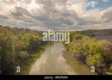 The Monocacy River in western Maryland. Smokestacks of the Dickerson electric power plant are in distance.  The Amtrak train Capitol Limited crosses t Stock Photo