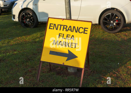 Yellow temporary entrance sign with direction arrow to a flea market event in a hall in Lincolnshire Showground, Lincoln, Lincolnshire, UK Stock Photo