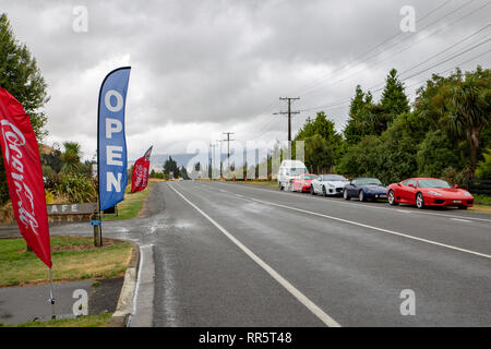 Springfield, Canterbury, New Zealand, February 24 2019: luxury cars parked along a main rural highway outside a cafe Stock Photo