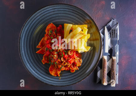 Portuguese  goulash with tomato and olives sauce and fried potato Stock Photo