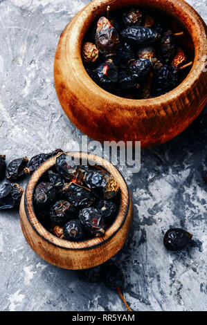 Dried red rose hips in bowl.Medicinal plants Stock Photo