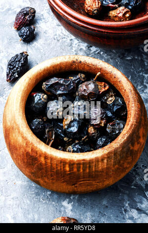 Dried red rose hips in bowl.Medicinal plants Stock Photo