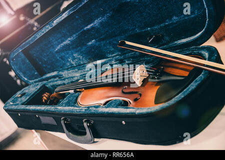 Violin on its case. Blue velvet violin case at music store Stock Photo