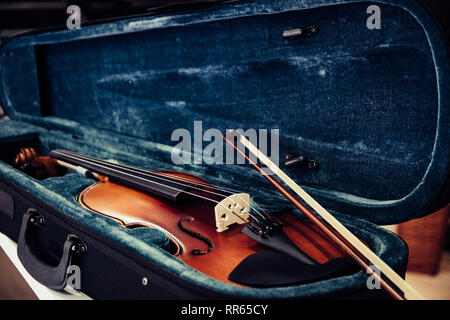 Violin on its case. Blue velvet violin case at music store Stock Photo