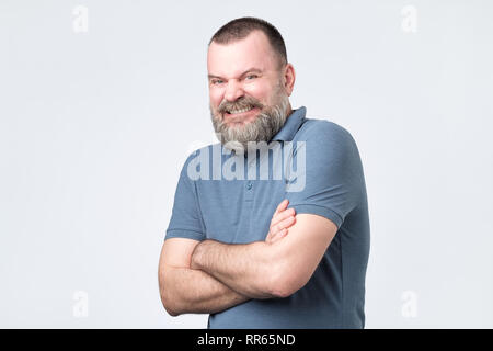 Smiling attractive mature man with beard in blue t-shirt looking directly at the camera Stock Photo