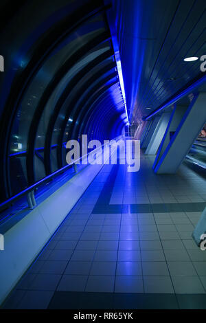 Covered pedestrian arch bridge at night Stock Photo