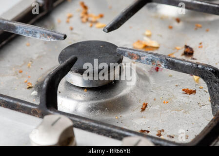 Dirty old kitchen gas burner. Fragment of a gas stove, close-up. Stock Photo