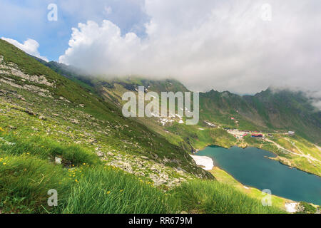 summer time in romanian carpathians. beautiful landscape of fagaras mountains. lake balea down in the valley. cloud approaching the ridge. view from t Stock Photo