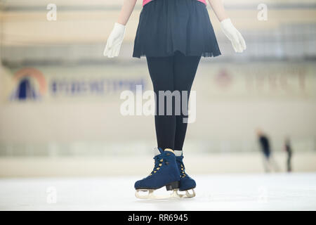 Low section portrait of unrecognizable figure skater standing on ice rink in cute outfit, copy space Stock Photo