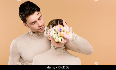 tender boyfriend with alstroemeria flowers on hand touching face