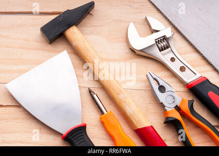 Level, spatula, screwdriver, hammer, pliers, adjustable wrench, saw. Set of construction tools on a concrete background Stock Photo