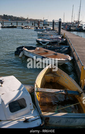 Dinghies tied up alongside a marina Stock Photo