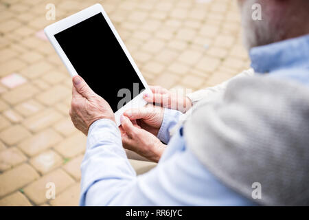 senior couple using digital tablet while sitting together Stock Photo