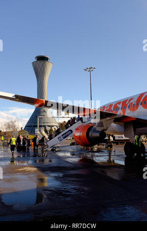Passengers boarding an easyjet plane at Edinburgh airport viewed from under the wing as the climb steps up Scotland UK Stock Photo