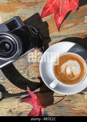 retro camera on tabletop with autumn leaves Stock Photo