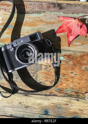 retro camera on tabletop with autumn leaves Stock Photo