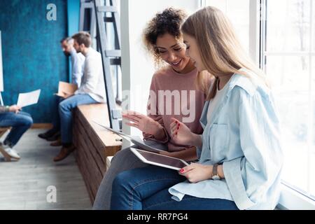 Creative female designers working in team. Two Businesswomen Having Informal Meeting In Modern Office. Stock Photo