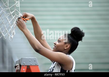 Player participating in a traditional cutting down of the net following a regional championship game victory. USA. Stock Photo