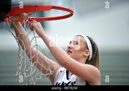Player participating in a traditional cutting down of the net following a regional championship game victory. USA. Stock Photo